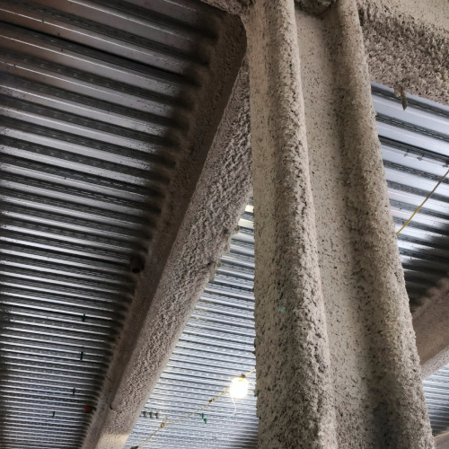 building-vertical-support-beam-covered-with-fireproofing-materials Image description